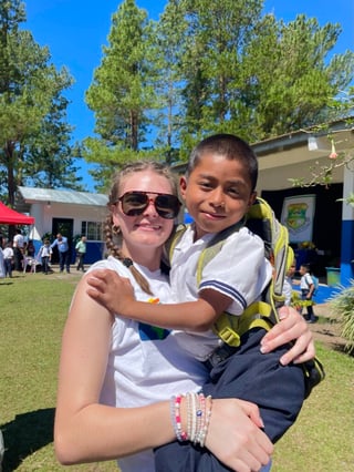 Weathley, a student participant, during a Service Learning Trip to Panama, hugging a local child.